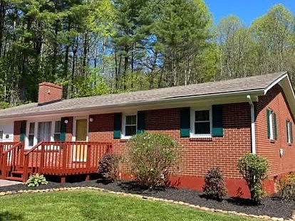 A brick ranch home with a freshly mulched and edged bed wrapping the foundation